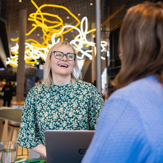Helga Opsett foran PC sammen med kunde.