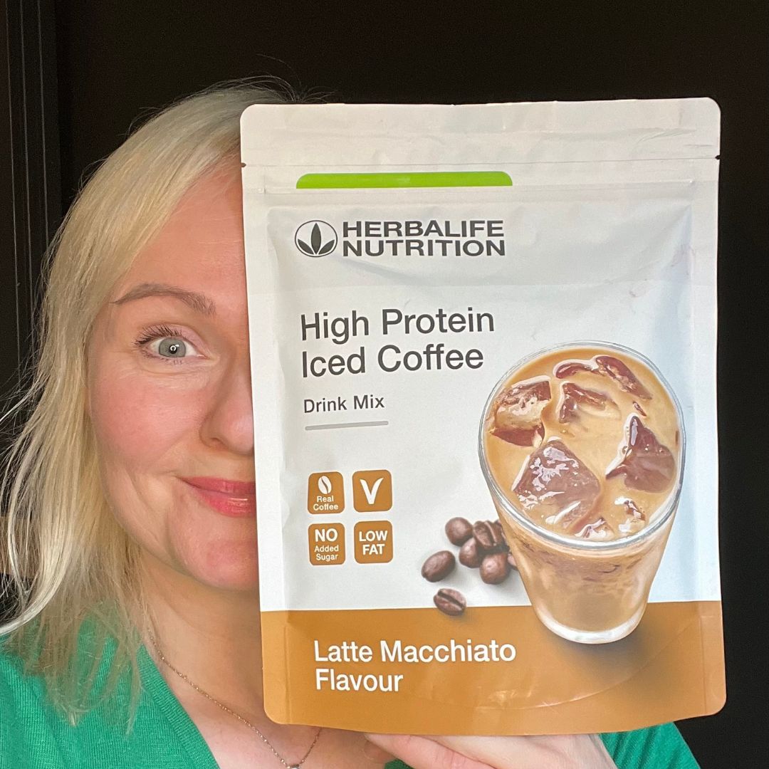 Helga Opsett holder frem en pose Herbalife proteiniskaffe latte.