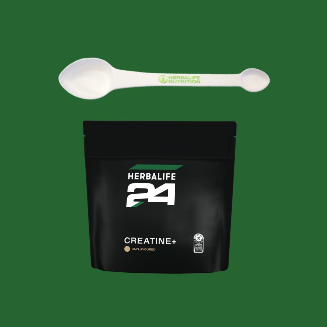 Hvit Herbalife 4-i-1 måleskje med grønn logo, plassert over en svart pose med Herbalife24 Creatine+ kosttilskudd. Produktfoto på grønn bakgrunn.