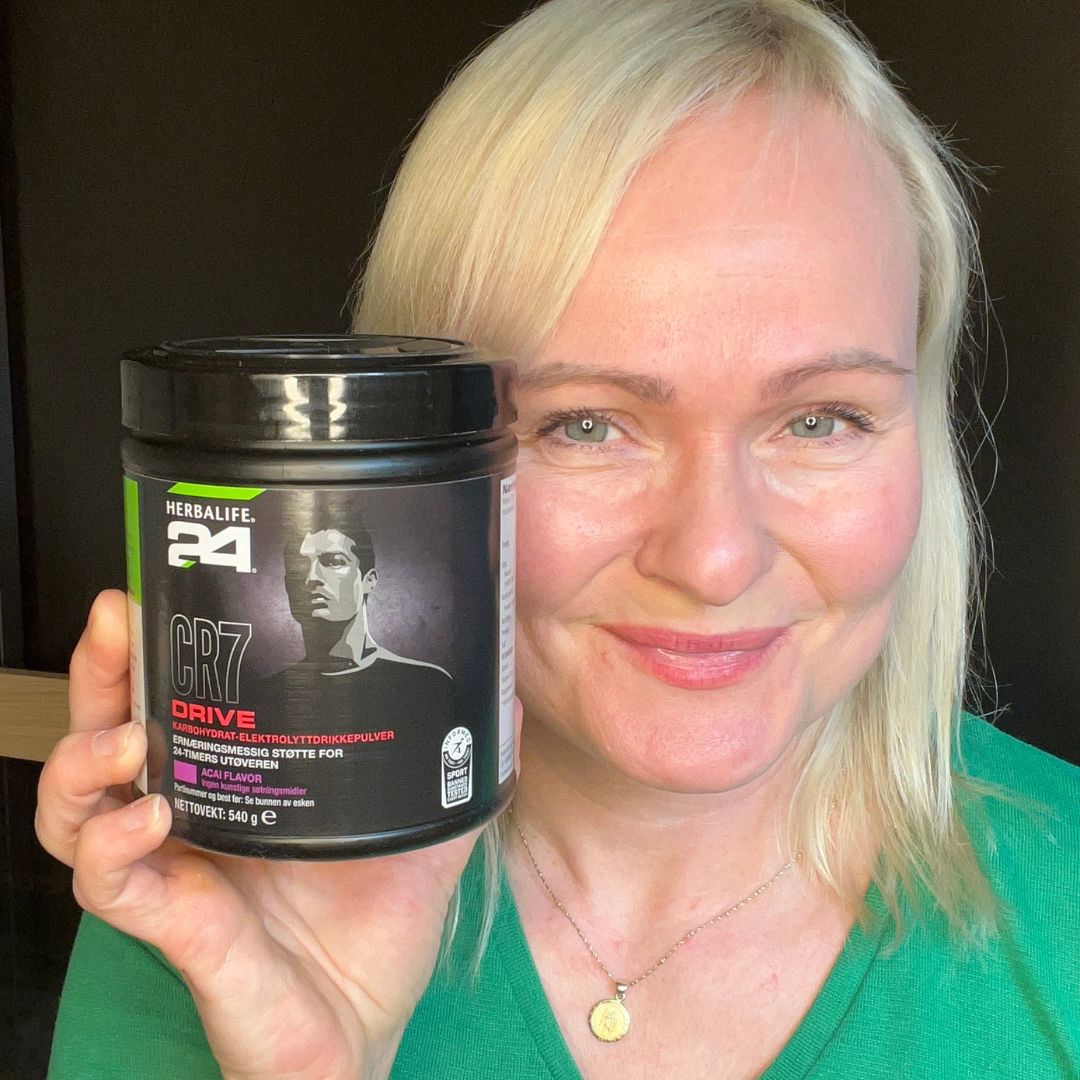 En box Herbalife H24 CR7 Drive sportsdrikk og Helga som viser den frem.