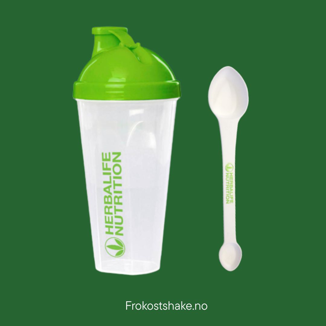Gjennomsiktig Herbalife shaker (400 ml) med grønt lokk og logo, ved siden av en hvit 4-i-1 måleskje med Herbalife-logo. Produktfoto på grønn bakgrunn.
