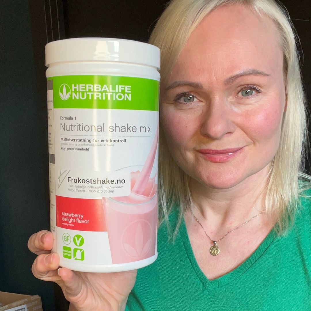 Boks Herbalife Formula 1 shakemix med jordbærsmak og Helga som holder den.
