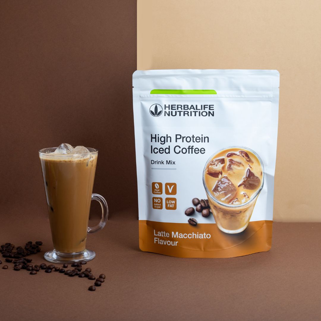 En pakke Herbalife High Protein Iced Coffee Drink Mix Latte Machiato-smak og et glasskrus med en protein-iskaffe.