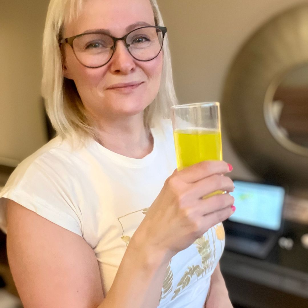 Bilde av en kvinne og et glass Herbalife Liftoff energidrikk.