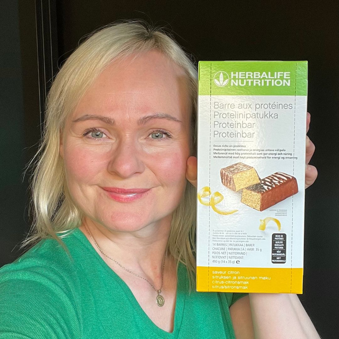 Proteinbarer med sitronsmak Herbalife i eske og Helga som holder den.