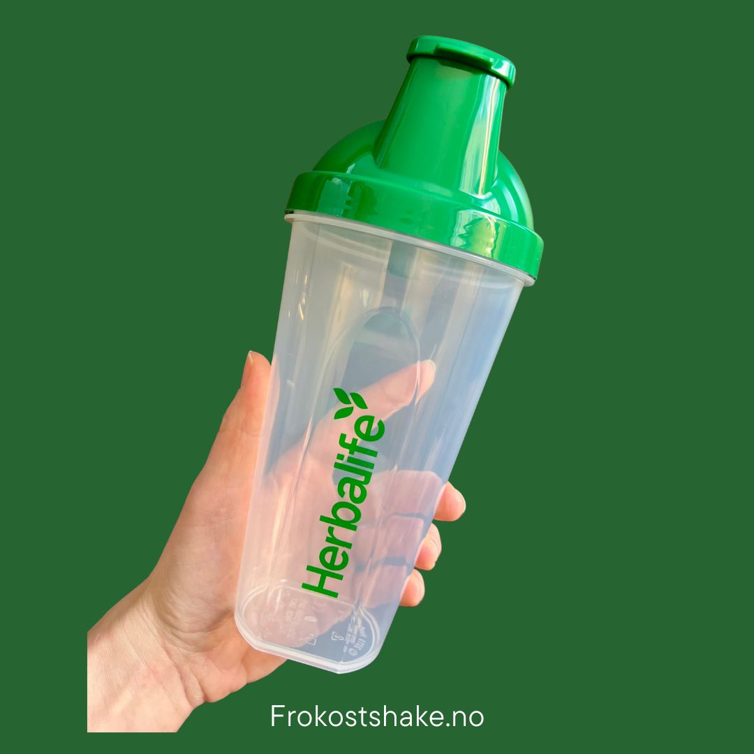 Shakerflaske med Herbalife-logo i handa på grønn bakgrunn fra Frokostshake.no.