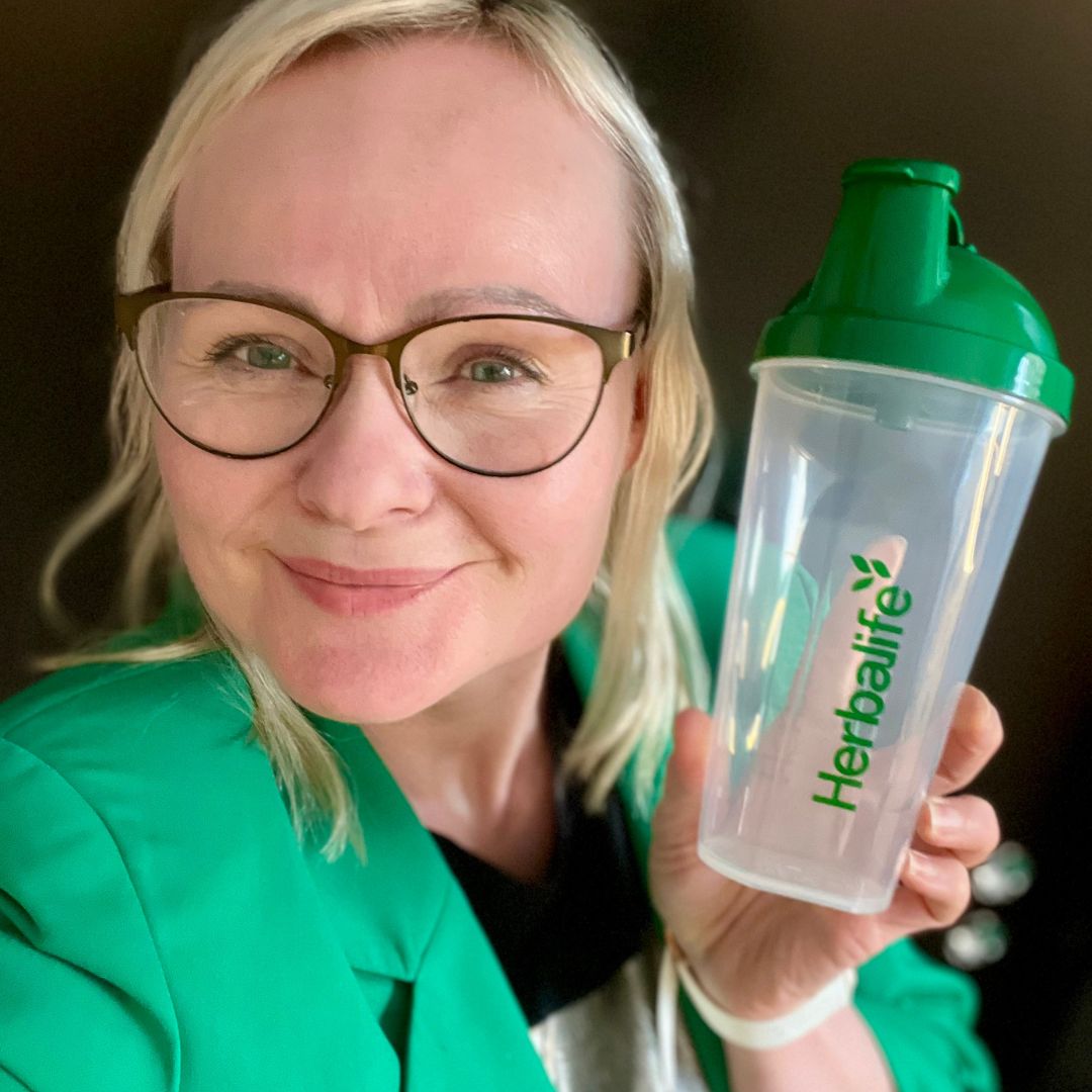 Shakerflaske med Herbalife-logo og Helga som holder den i handa.