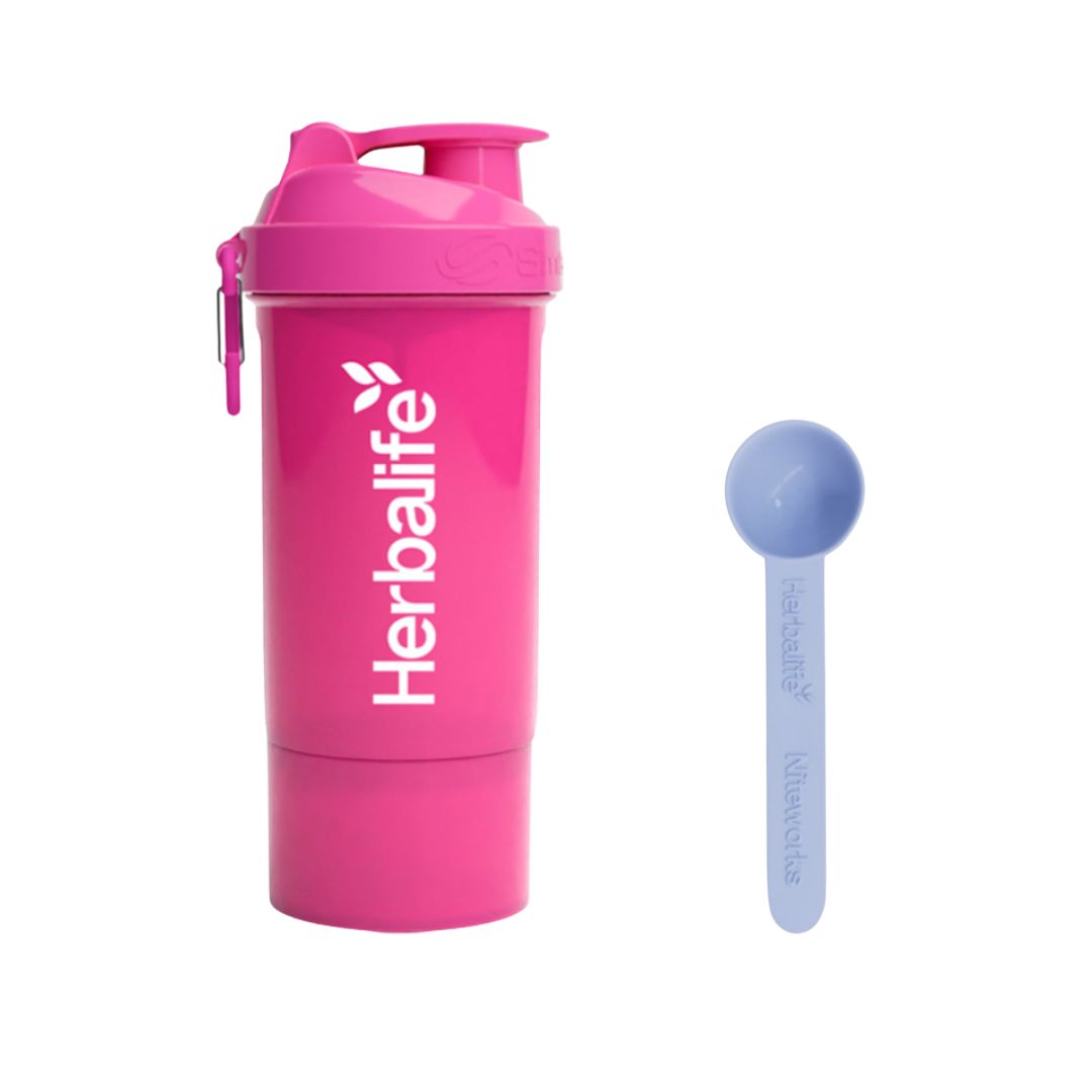 Rosa Herbalife SmartShake 600 ml med hvit logo og karabinkrok, plassert ved siden av en blå Herbalife-måleskje. Produktfoto på hvit bakgrunn.