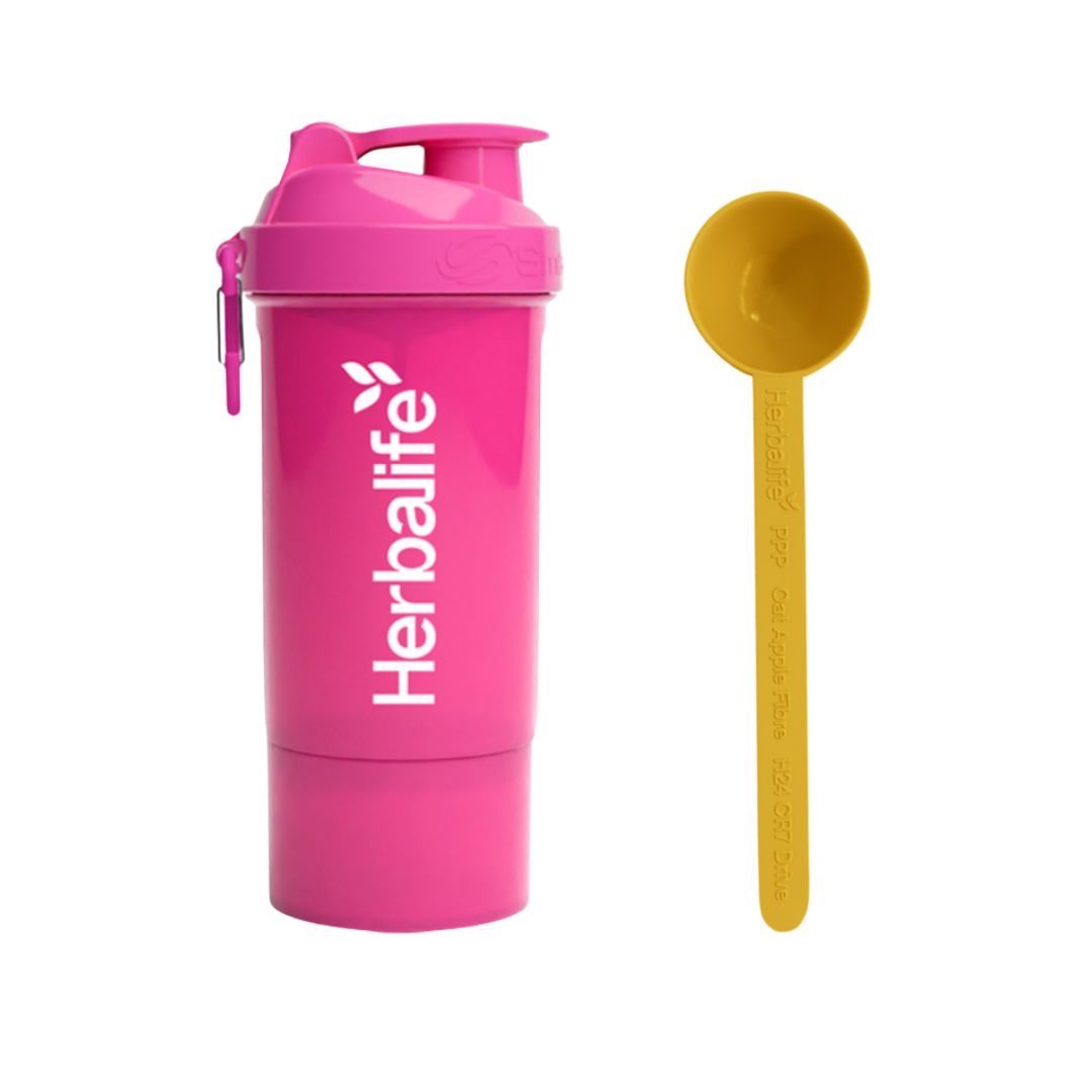 Rosa Herbalife SmartShake 600 ml med hvit logo og karabinkrok, plassert ved siden av en gul Herbalife-måleskje. Produktfoto på hvit bakgrunn.