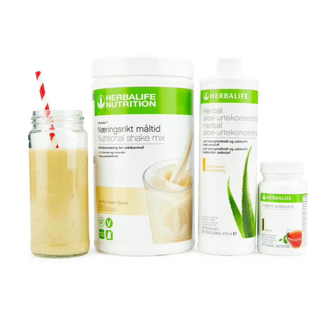 Bildet viser Herbalife-produktene som Frokostpakke basic består av; Herbalife-shake med vaniljesmak, Herbal Aloe aloevera-juice med mangosmak og Instant urtete med original-smak samt en vaniljeshake i et glass med sugerør.
