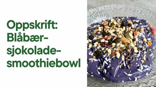 Blå smoothiebowl i en glasskål toppet med nøtteblanding. Tekst: Oppskrift: Blåbær-sjokolade-smoothiebowl.