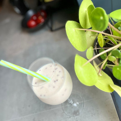 En Herbalife cookie crunch-shake i et glass med sugerør på en kjøkkenbenk. 