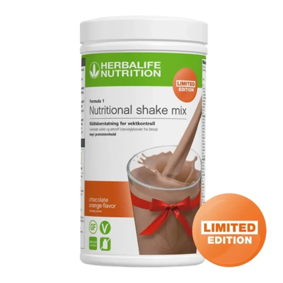 En boks Herbalife Formula 1 Nutritional shakemix med Limited Edition Chocolate Orange-smak. Boksen er merket glutenfri og vegansk og har bilde av en appelsinsjokolade-shake som helles i et glass med Herbalife-logo og rød sløyfe rundt. 