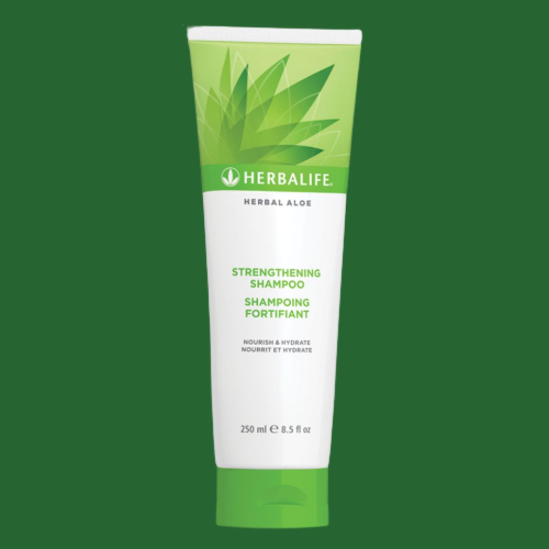 Tube med Herbalife Herbal Aloe Strengthening Shampoo mot grønn bakgrunn. Tekst på sjampoflaska: Nourish & Hydrate, 250 ml.