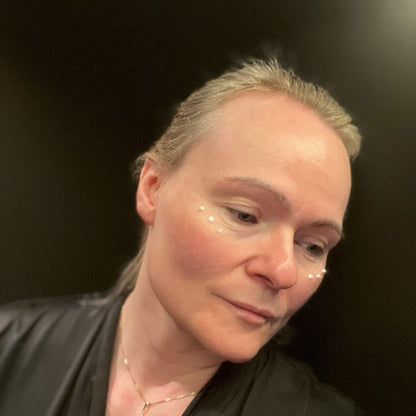 Nærbilde av kvinne som påfører HL/SKin Nourishing Eye Cream - små kremprikker under øynene,  for fukt og glattere hud.