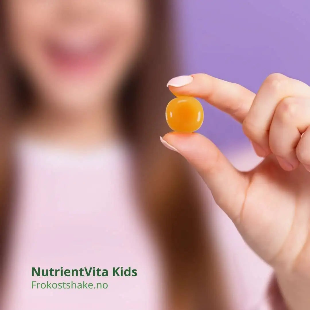 En jente holder en Herbalife Gels NutrientVita Kids multivitamin tyggetablett.