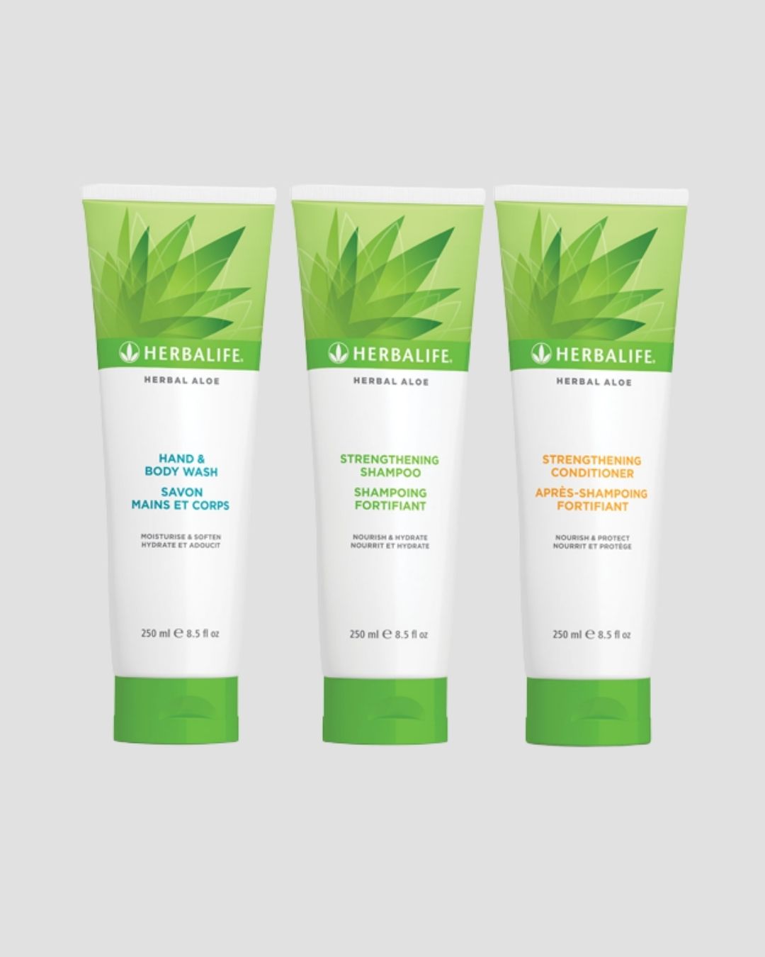 En tube Herbalife Herbal Aloe Strengthening Shampoo, Strengthening Conditioner og Hand & Body Wash på grå bakgrunn.