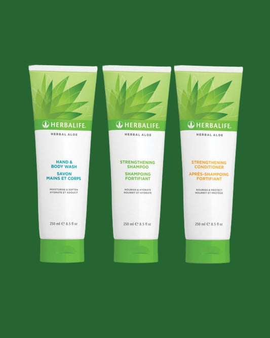 En tube Herbalife Herbal Aloe Strengthening Shampoo, Strengthening Conditioner og Hand & Body Wash på grønn bakgrunn.