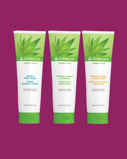 En tube Herbalife Herbal Aloe Strengthening Shampoo, Strengthening Conditioner og Hand & Body Wash på lilla bakgrunn.