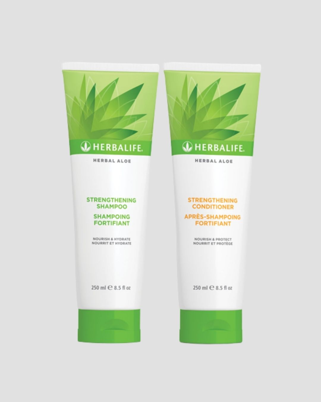 En tube Herbalife Herbal Aloe Strengthening Shampoo og Strengthening Conditioner på grå bakgrunn.