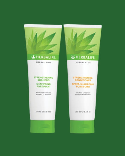 En tube Herbalife Herbal Aloe Strengthening Shampoo og Strengthening Conditioner på grønn bakgrunn.