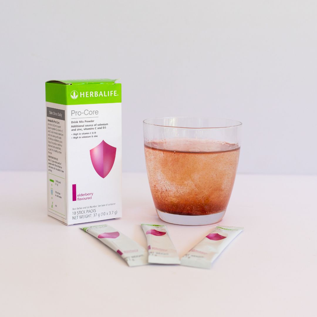 En pakke Herbalife Immune Booster, tre løse porsjonsposer og et glass vann med Immune Booster som løses opp. 