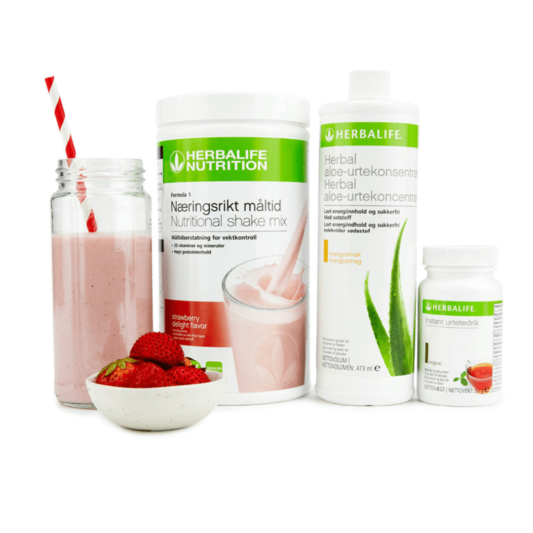 Bildet viser Herbalife-produktene som Frokostpakke basic jordbær består av; Herbalife-shake med jordbærsmak, Herbal Aloe aloevera-juice med mangosmak og Instant urtete med original-smak samt en jordbærshake i et glass med sugerør og noen jordbær i en skål. 