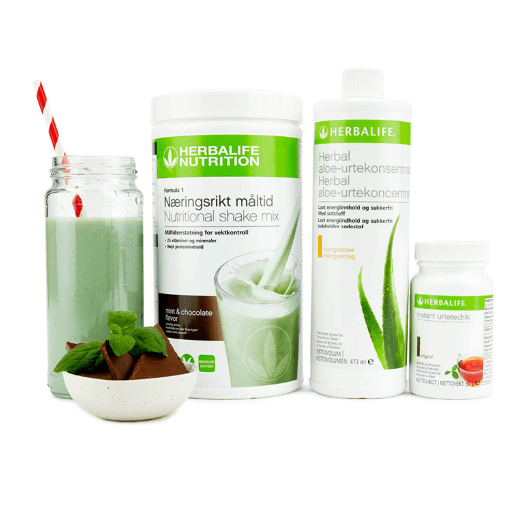 Bildet viser Herbalife-produktene som Frokostpakke basic Mint & Chocolate består av; Herbalife-shake med mintsjokolade-smak, Herbal Aloe aloevera-juice med mangosmak og Instant urtete med original-smak samt en Herbalife mint og sjokolade-shake i et glass med sugerør og noen sjokoladebiter og mynteblad i en skål.