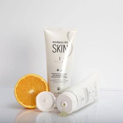 To tuber Herbalife SKIN Citrus Cleanser på et bord, hvor den ene ligger åpnet og litt av produktet har rent ut. Her ses mikrokulene i rensegeleen.