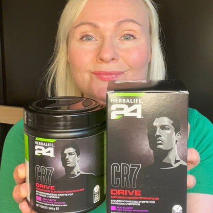 Helga og en boks Herbalife H24 CR7 Drive pulver og en boks porsjonsposer. 