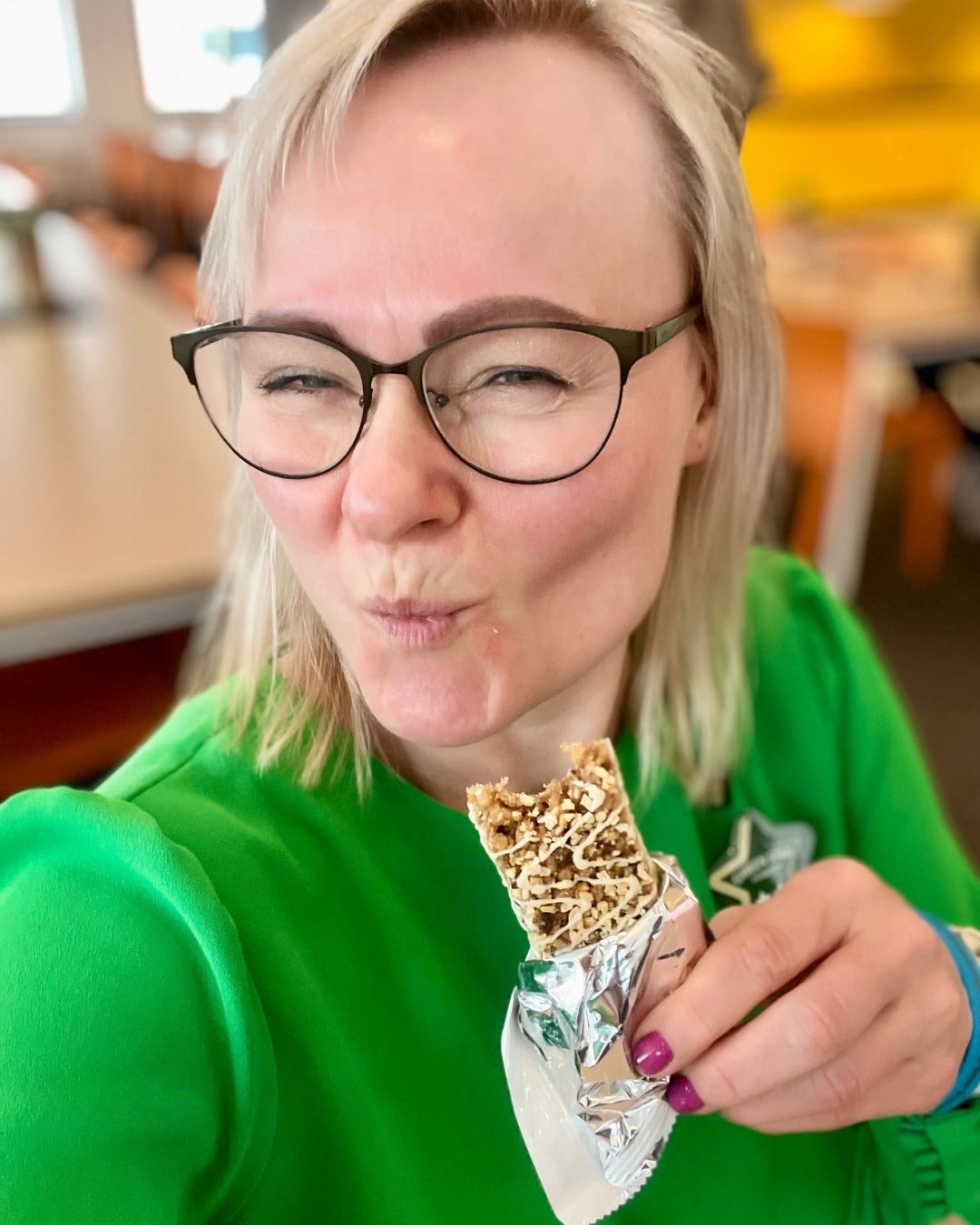 Helga i grønn kjole som spiser en Herbalife Formula 1 Expressbar måltidsbar Tranebærsmak - Cranberry & White Chocolate flavor