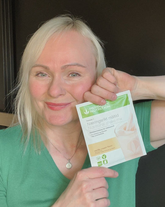 Helga Opsett holder en Herbalife Formula 1 vaniljeshake porsjonspose