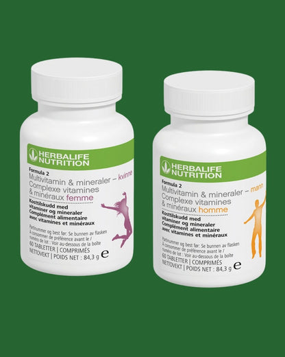 Multivitamin-bokser på grønn bakgrunn. En vitaminboks for kvinne og en for mann. Boksene har påskriften Herbalife Formula 2 Kosttilskudd med vitaminer og mineraler - kvinne og - mann. 