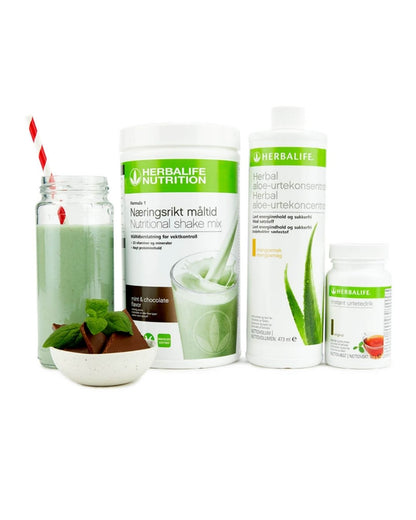 Herbalife-produktene som Frokostpakke basic Mint & Chocolate består av; Herbalife-shake med mintsjokolade-smak, Herbal Aloe aloevera-juice med mangosmak og Instant urtete med original-smak samt en Herbalife mint og sjokolade-shake i et glass med sugerør og noen sjokoladebiter og mynteblad i en skål.