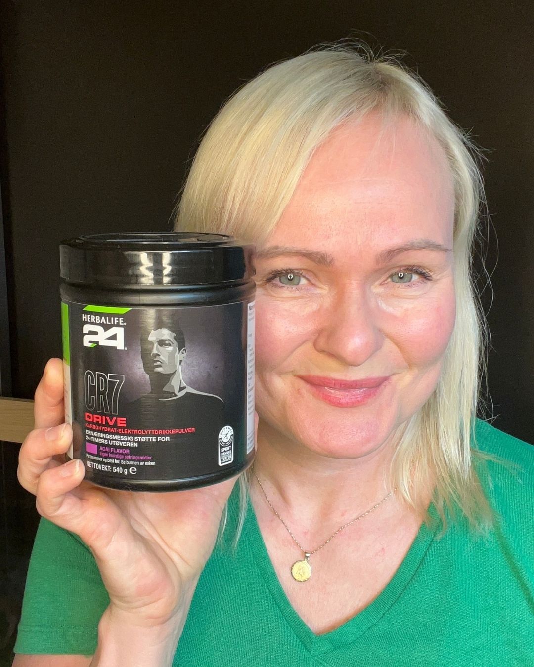 En box Herbalife H24 CR7 Drive sportsdrikk og Helga som viser den frem. 