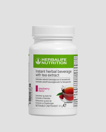 En boks Herbalife Instant Raspberry urtekonsentrat te med bringebærsmak, 51 gram, grå bakgrunn.