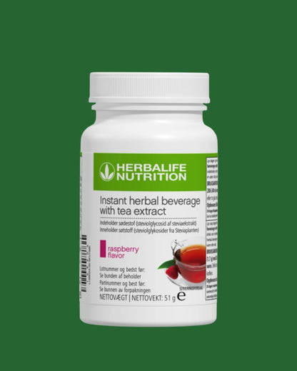En boks Herbalife Instant Raspberry urtekonsentrat te med bringebærsmak, 51 gram, grønn bakgrunn.