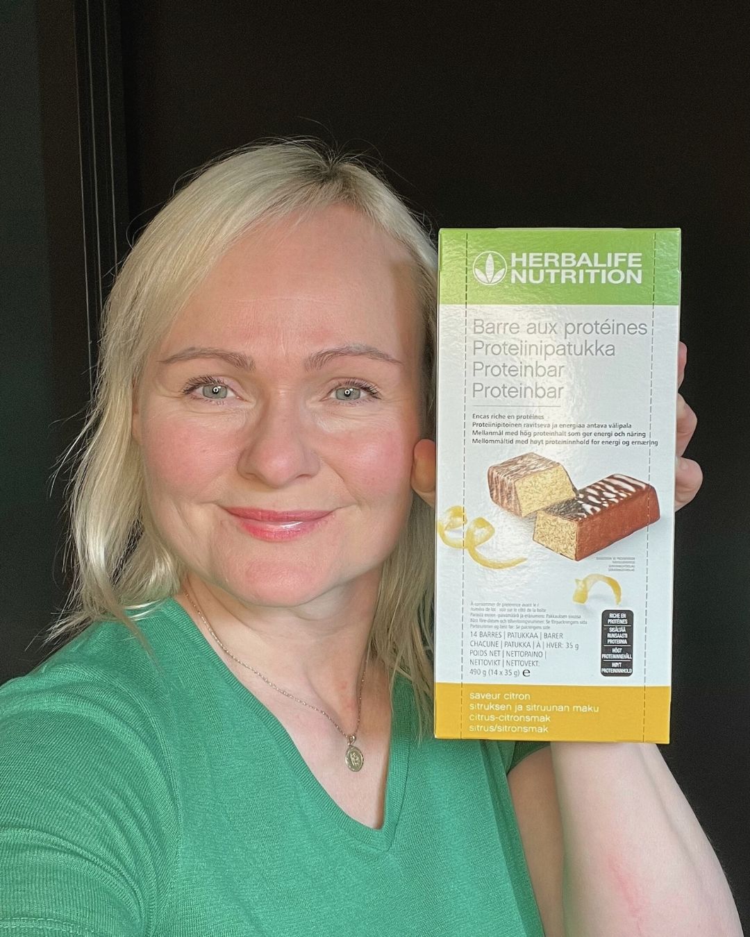 Proteinbarer med sitronsmak Herbalife i eske og Helga som holder den. 