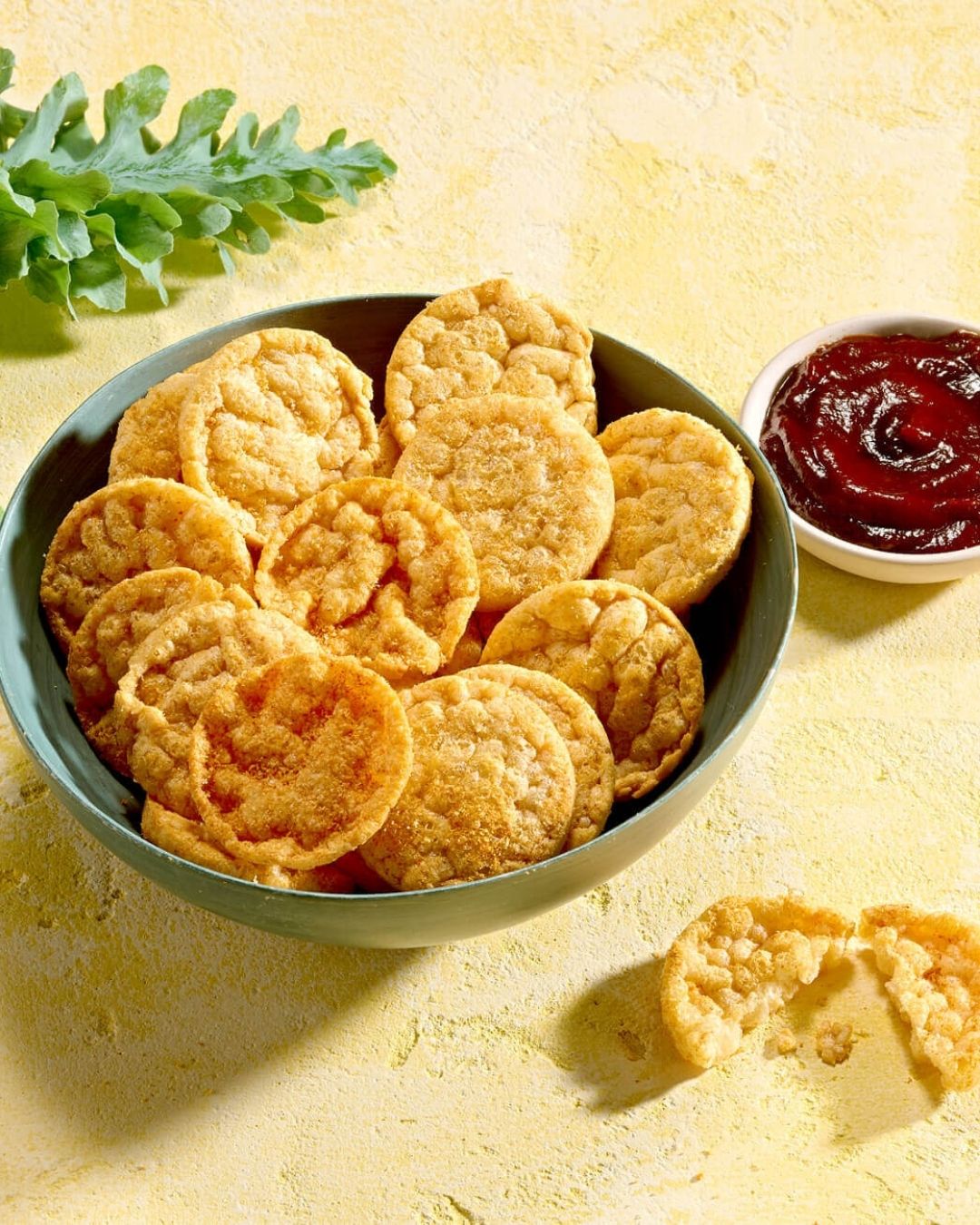 En skål Herbalife Protein Chips proteinrik snacks med barbecue-smak og en skål med barbeque-saus.