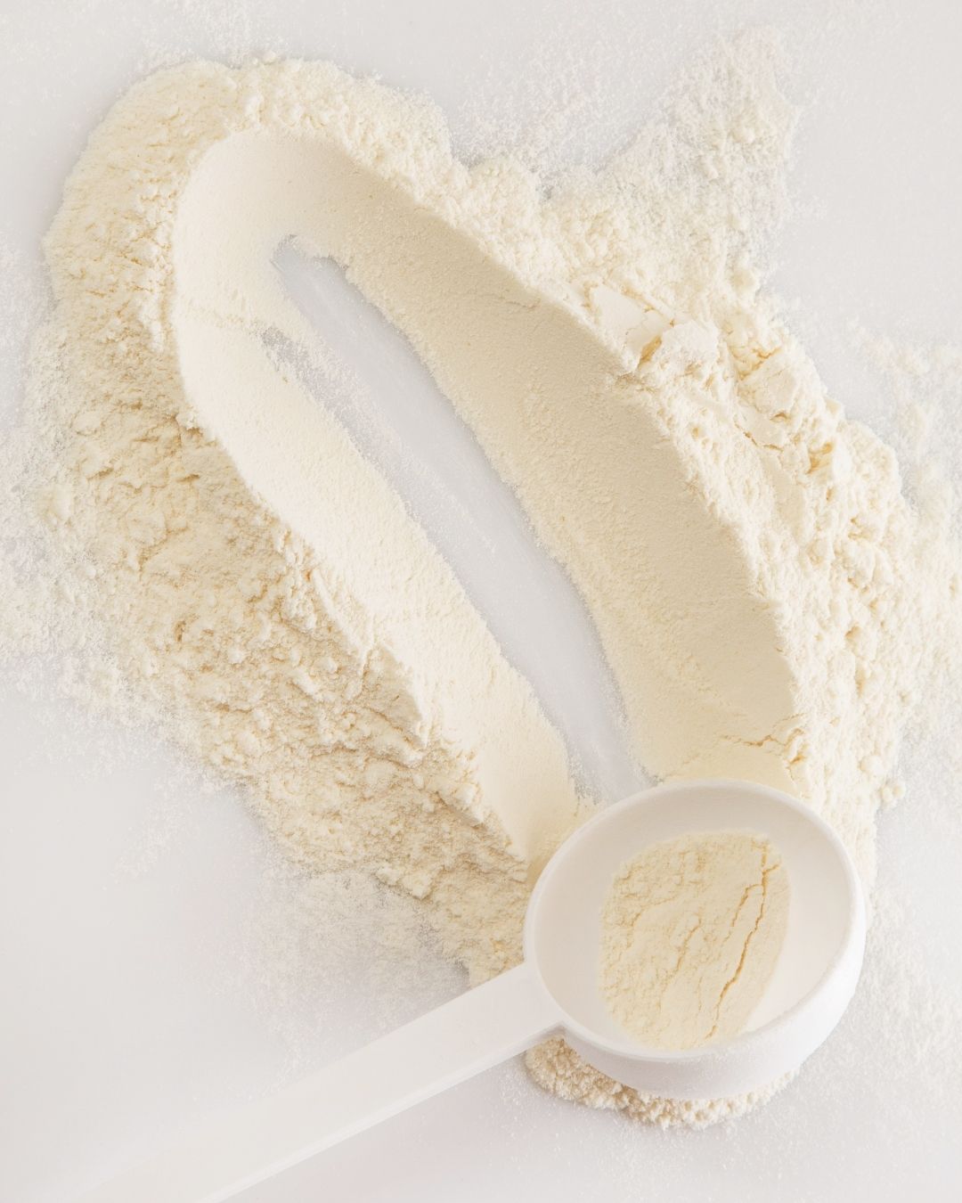 Proteinpulver og måleskje på et bord.