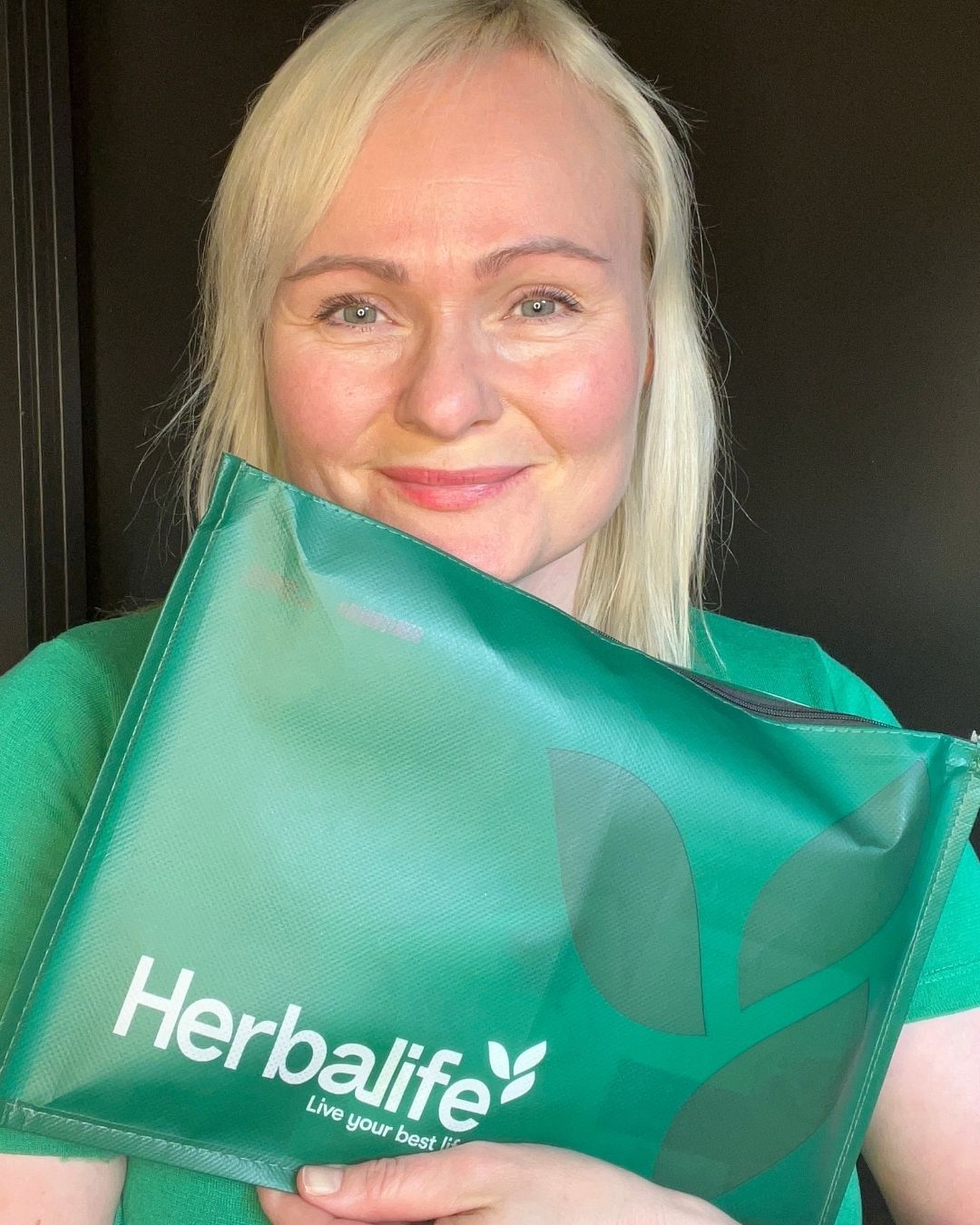 Helga Opsett holder frem en pakke Herbalife prøvepakke md shake og instant urtete.