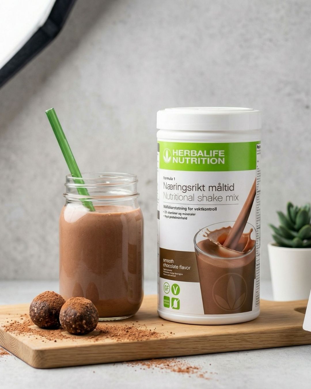 Herbalife sjokoladeshake servert i glass på trebrett med sjokoladebiter