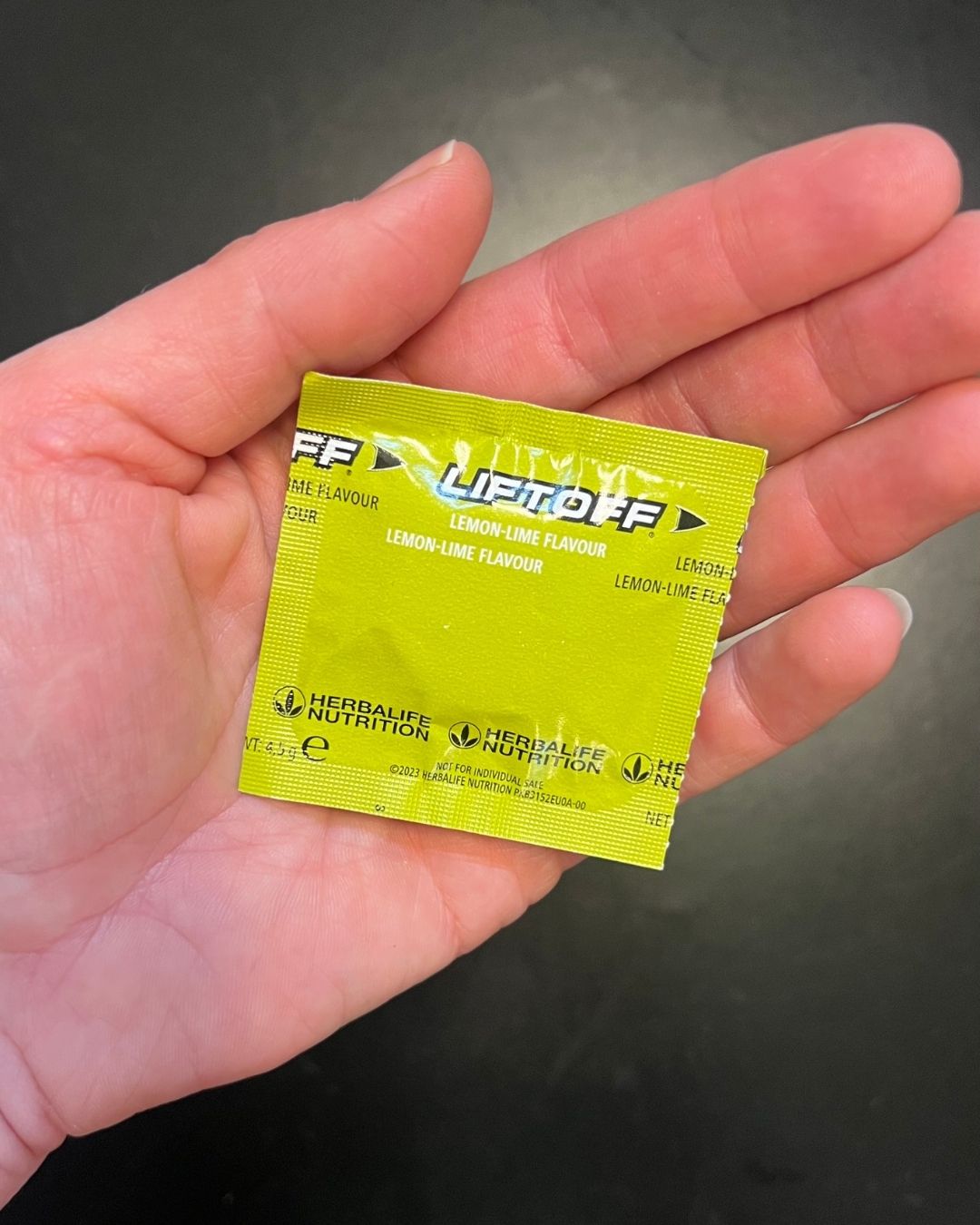 En brusetablett LiftOff innpakket, holdes i ei hånd