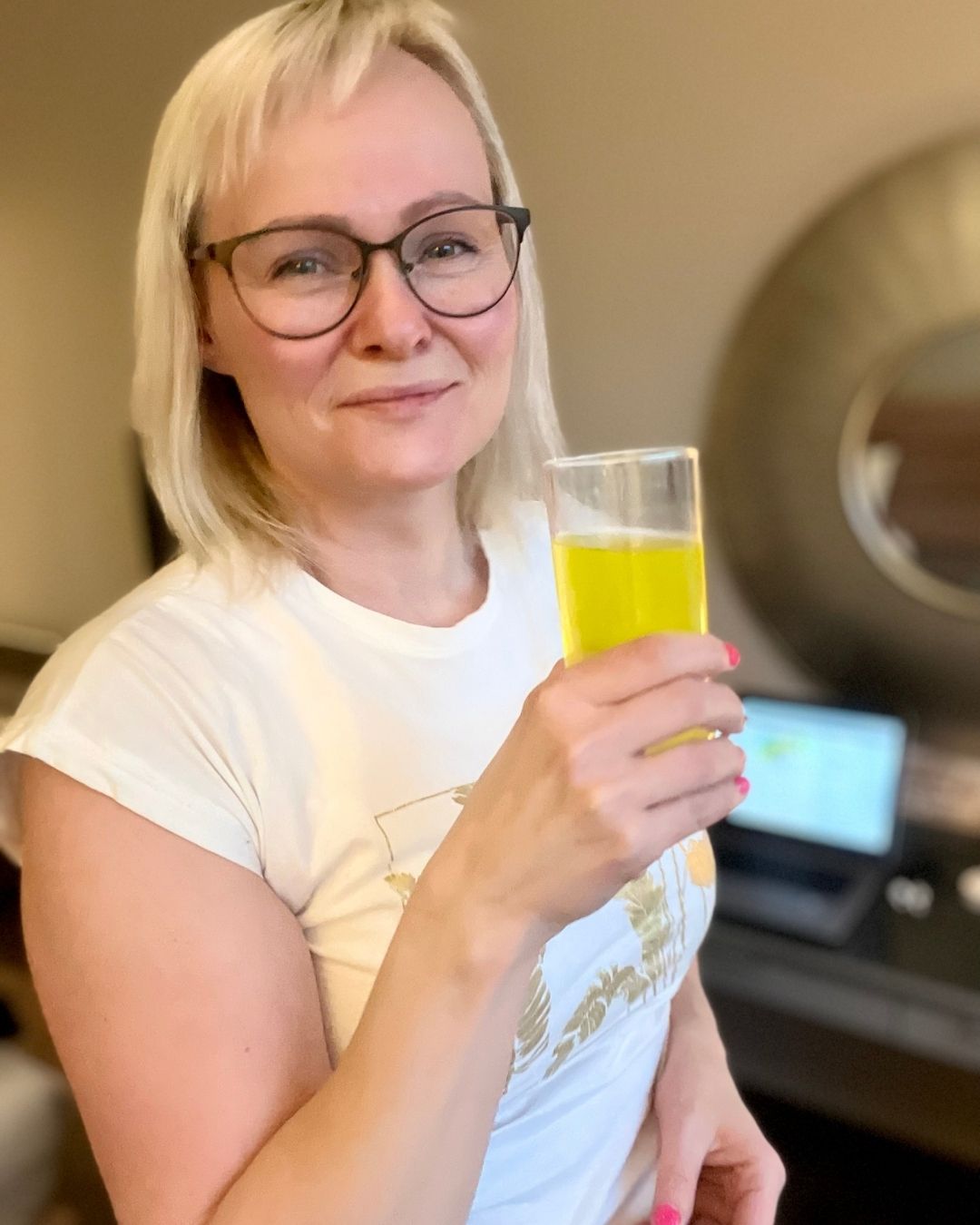 Et glass Herbalife Liftoff energidrikk og Helga Opsett som holder det i hånda. 