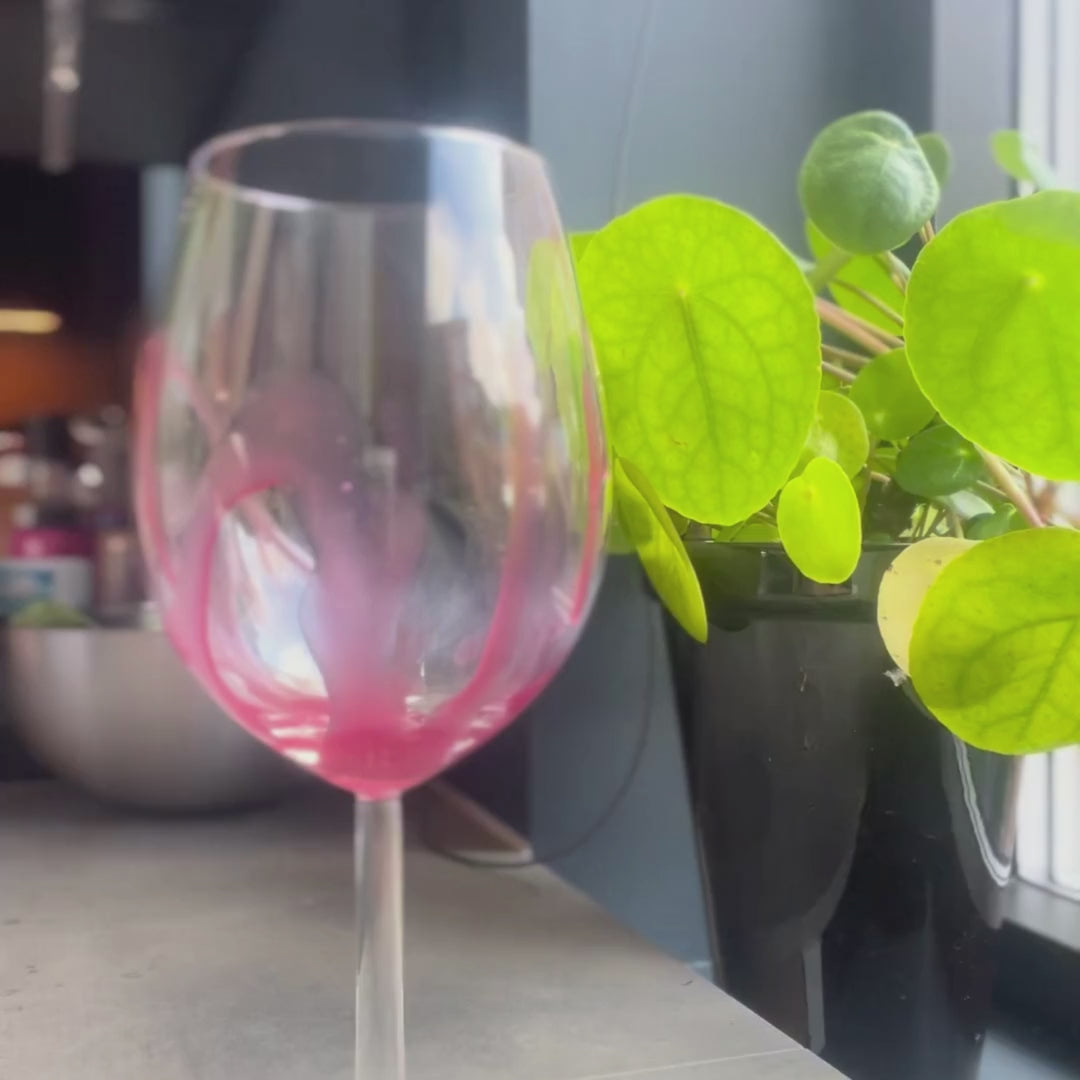 Video som viser en smoothie som helles i et rødvinsglass. Filmet med filmatisk effekt på iPhone. Glasset er et tomt rødvinsglass, dekorert med rødsaus. Smoothien helles fra en glasskoble tilhørende en blender. Dette er på et kjøkken, kjøkkenbenken er grå kjeramikk, og i bakgrunnen ses lys og en grå stålbolle og litt oppvask. I vinduskarmen til høyre ses en elefantøre i en sort blomsterpotte. På slutten av videoen ses en hvithudet kvinnehånd med hvit klokke og rosa neglelakk. Frokostshake.no