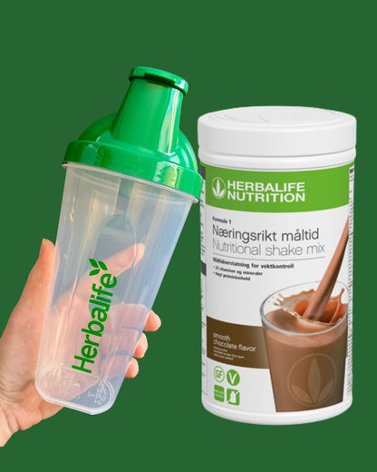 Sjokolade Herbalife shake-boks og shakerflaske i hånden på grønn bakgrunn, Frokostshake.no. 