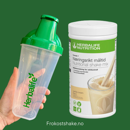 Vanilje Herbalife shake-boks og shakerflaske i hånden på grønn bakgrunn, Frokostshake.no. 